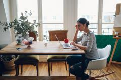 jeune femme devant son ordinateur dans un salon